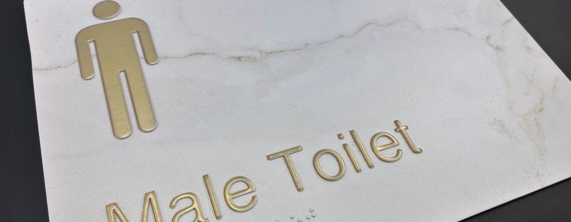 Brass Raised Graphics on White Marble Braille Sign