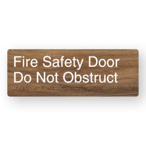 Fire Safety Door Do Not Obstruct Braille Sign in a Mid-Tone Woodgrain - Image 1