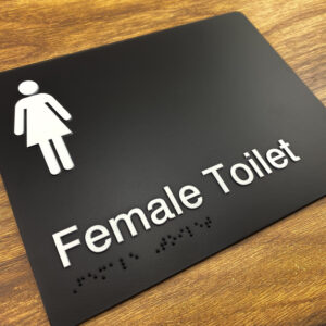 Female Toilet Braille Sign in Black Moulded Acrylic. Black Sign panel with White Female Symbol, White Text that reads Female Toilet