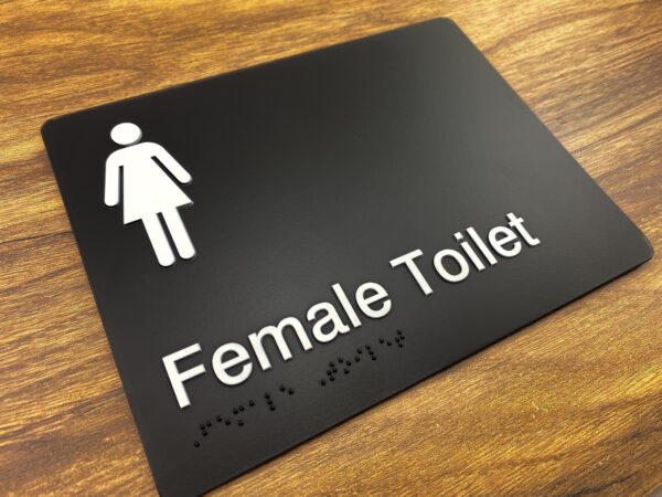 Female Toilet Braille Sign in Black Moulded Acrylic. Black Sign panel with White Female Symbol, White Text that reads Female Toilet