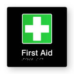First Aid Braille Sign in Black tactile printed Acrylic. Black Sign panel with Green & White first Aid Symbol. White text reads First Aid. White Braille is Shown
