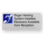 Roger Hearing System Installed, Receivers Available from Reception Braille Sign in Anodised Aluminium. Silver Sign panel with Bklue & White Hearing Symbol, Black text reads Roger Hearing System Installed, Receivers Available from Reception