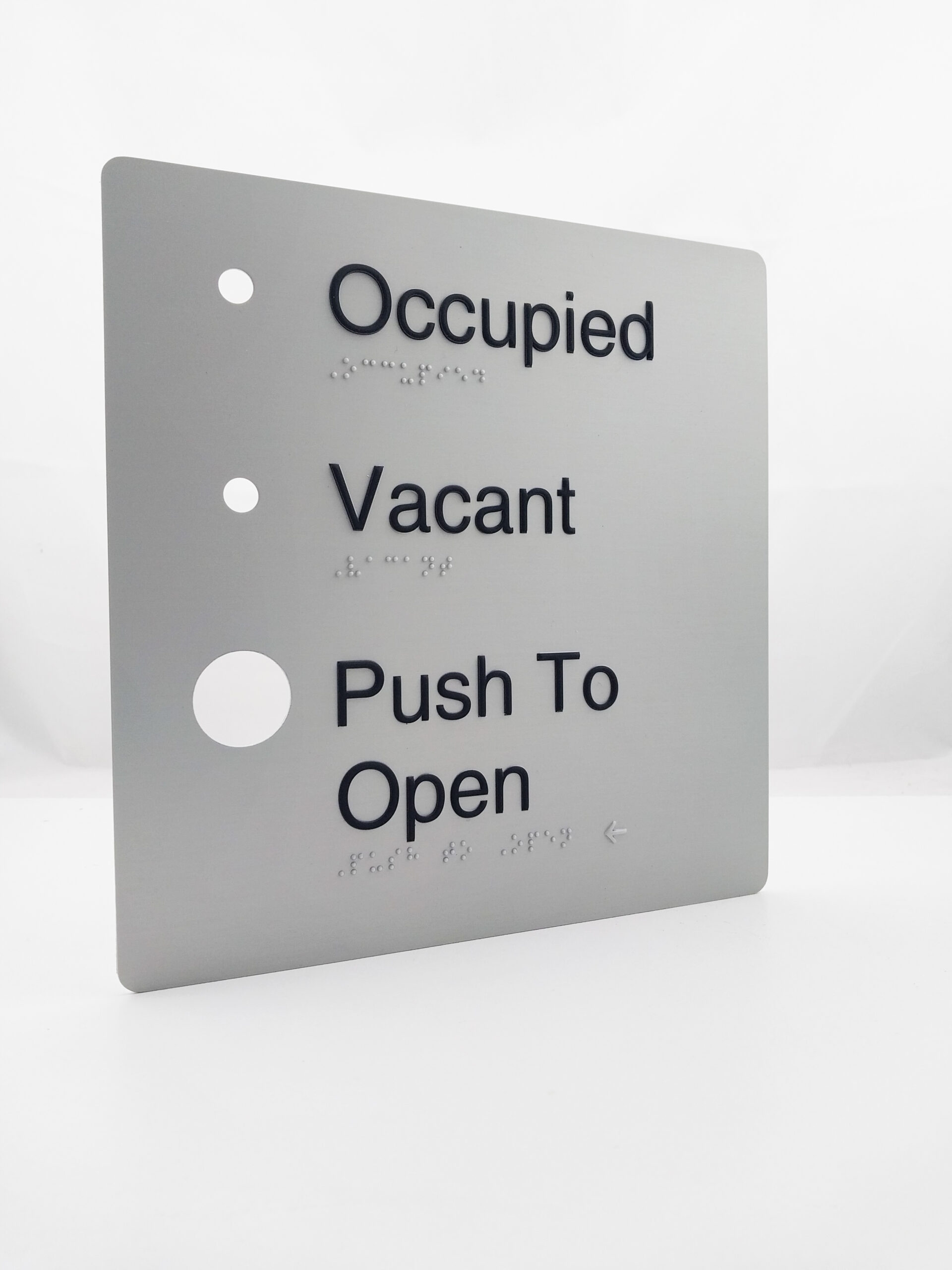 Automatic Door Occupied, Vacant, Push to Open Braille Sign in Anodised Aluminium. Silver sign panel with Black raised text 7 Braille. Button hole cutouts are also shown