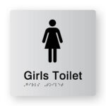 Girls Toilet Braille Sign in Tactile Printed Silver Acrylic. Silver Sign panel with Black Female Symbol. Black Text reads Girls Toilet. Black Braille is Shown