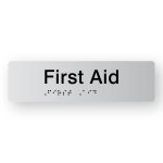First Aid Braille Sign in Tactile printed Silver Acrylic. Silver Sign panel with Black Text that reads First Aid. Black Braille is shown