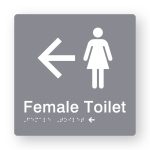 Female Toilet Braille Sign with Left Arrow in Tactile printed Grey Acrylic. Grey Sign panel with White Female Symbol & Left Arrow. White text reads Female Toilet. White Braille is shown