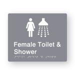 Female Toilet & Shower Braille Sign in Grey Tactile printed Acrylic. Grey Sign panel with white Female & Shower Symbols. White Text reads Female Toilet & Shower. White Braille Text is shown
