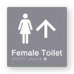 Female Toilet Braille Sign with Up Arrow in Tactile printed Grey Acrylic. Grey Sign panel with White Female Symbol & Up Arrow. White text reads Female Toilet. White Braille is shown