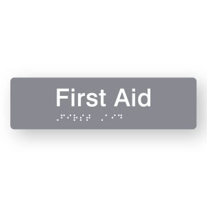 First Aid Braille Sign in Tactile printed Grey Acrylic. Grey Sign panel with White Text that reads First Aid. White Braille is shown