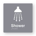Shower Braille Sign in Grey Tactile printed Acrylic. Grey Sign panel with white Shower Symbols. White Text reads Shower. White Braille Text is shown