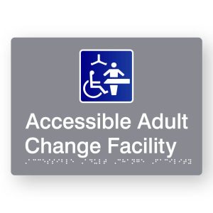 Accessible Adult Change Facility Braille Sign in Tactile printed Grey Acrylic. Grey Sign panel with Blue & White Changing Places Symbol. White text reads Accessible Adult Change Facility. White Braille is shown
